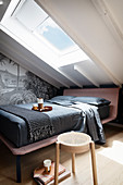Doppelbett und Motivtapete im Schlafzimmer unter dem Dach