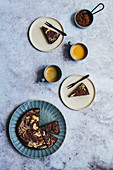 Tahini Brownies baked in round cake tin served with coffee