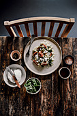 Hirsesalat mit Hüttenkäse, Spinat und Feigen auf rustikalem Holztisch
