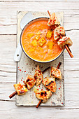 Coconut and pepper soup with chicken skewers