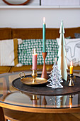 Colourful candles in different candle holders and Christmas-tree decorations
