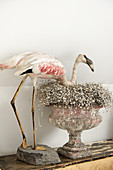A stuffed flamingo and an antique urn