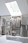 Old window frames and shabby-chic style decorative objects below a skylight