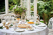 Gedeckter Teetisch mit Kuchen und Gebäck auf Terrasse