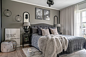 A double bed in a bedroom with a taupe wall