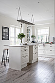 A glass holder hanging above a kitchen island