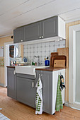 A kitchen sink unit with grey fronts