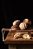 Freshly baked traditional concha bread placed on wooden cutting board on black background