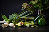Verschiedene grüne Gemüsesorten auf dunklem Holztisch