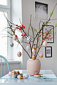 Zweige mit DIY-Ostereiern in einer Vase