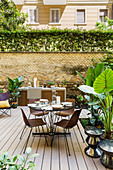 Runder Esstisch mit Stühlen und Outdoor-Küche auf der Terrasse