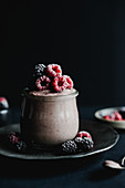 Fruit dessert in a jar with frozen raspberries and blackberries