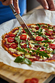 Keto-Pizza mit Salami, Mozzarella, Tomaten und Rucola