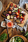 Grillgemüse mit Tomaten, Paprika, Auberginen und Zwiebeln auf Holzbrett