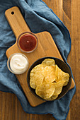 Crispy potato chips with ketchup and sour cream