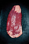 Raw flank steak on a dark background