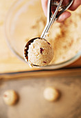 Cookie dough being shaped with an ice cream scoop