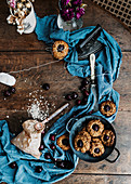 Baked cherry cookies placed on wooden table with piece of cloth and vintage iron