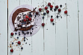 Vegan chocolate cake with coconut yoghurt glaze, cherries and blueberries