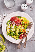Salad with zucchini, chicken, avocado, Parma ham and cucumber
