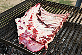 Raw beef ribs on a grilling rack