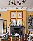Framed hand painted warriors hang above a marble mantlepiece, decorative pineapples adorn antique urns and the table
