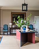 Modern table with bouquet of flowers in a classic living room