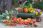 Erntetisch mit Tomaten, Kohlrabi, Gelbe Bete 'Burpees Golden', Zucchini, Hokkaido-Kürbis, Mangold, Sonnenblume und Strauß aus Aster und Ringelblumen