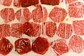 Marinated tuna slices between paper