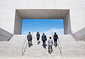 Business people ascending modern stairs