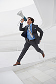 Leaping businessman with bullhorn