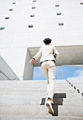 Businesswoman rushing up urban stairs