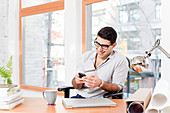 Businessman using cell phone in office