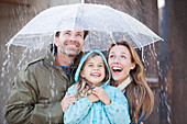 Enthusiastic family under umbrella