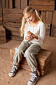 Girl holding chick in barn