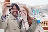 Laughing couple taking self-portrait