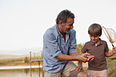 Smiling grandfather and grandson fishing