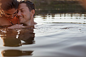Smiling couple swimming in lake