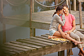 Couple sitting on dock over lake