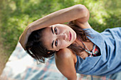 Woman sitting on blanket in grass