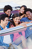 Smiling friends driving in convertible