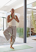 Older woman practicing yoga in home