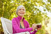 Older woman drinking tea outdoors