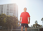 Older man playing tennis on court