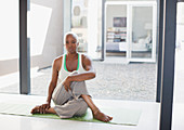 Older woman stretching on yoga mat