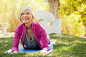 Older woman practicing yoga in backyard