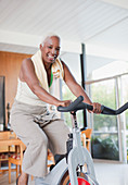 Older woman using exercise bike in home