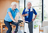 Older woman riding exercise bike at home