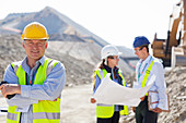 Businessman in hard hat smiling in quarry