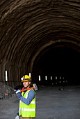 Worker holding sledgehammer in tunnel